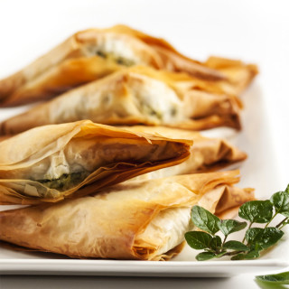 Spinach Feta Fillo Triangles - A great addition to a party or a fun side dish for a special meal, these Spinach Feta Triangles will be a hit with their classic combination of tasty spinach and salty, creamy cheese. | justalittlebitofbacon.com