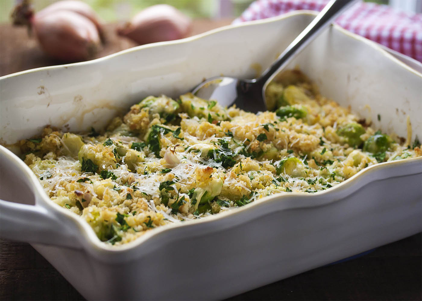 Easy Brussels Sprout and Shallot Gratin - In this brussel sprout gratin, brussel sprouts and shallots are roasted right in the casserole dish and then topped with cheese and breadcrumbs to make for an easy and light gratin. | justalittlebitofbacon.com
