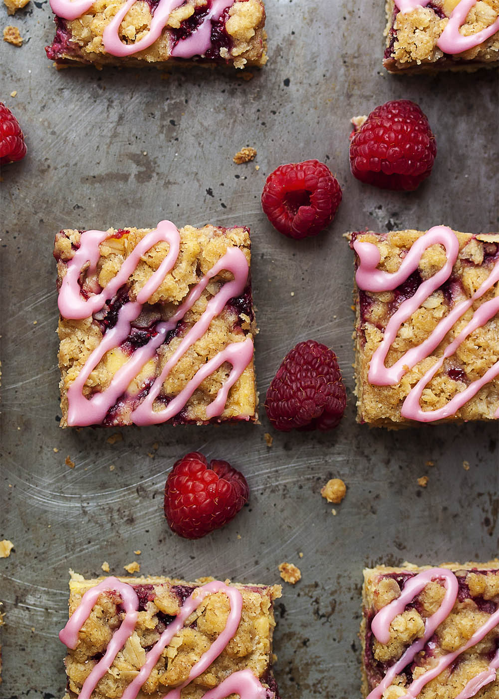 Raspberry Orange Streusel Bars - Raspberries pair with an orange cream filling and are topped by an oatmeal streusel in these flavorful and easy bar cookies. And, to make them extra fun and colorful, you can drizzle them with a raspberry glaze! | justalittlebitofbacon.com