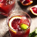 Blood Orange Bourbon Smash - Blood oranges give this Bourbon Smash a gorgeous ruby color. Maple syrup provides a bit of smokey, sweetness while lime and mint give the drink an extra pop of flavor. Have it as is for smooth sipping or add a splash of soda water for a lively cooler. | justalittlebitofbacon.com