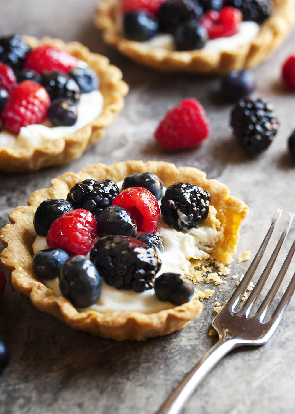 Mascarpone Fruit Tart - This fruit tart is filled a mixture of mascarpone cheese, cream cheese, and heavy cream all of which is whipped up and sweetened with maple syrup. It is then topped with mixed berries and brushed with a simple apricot jelly glaze. | justalittlebitofbacon.com