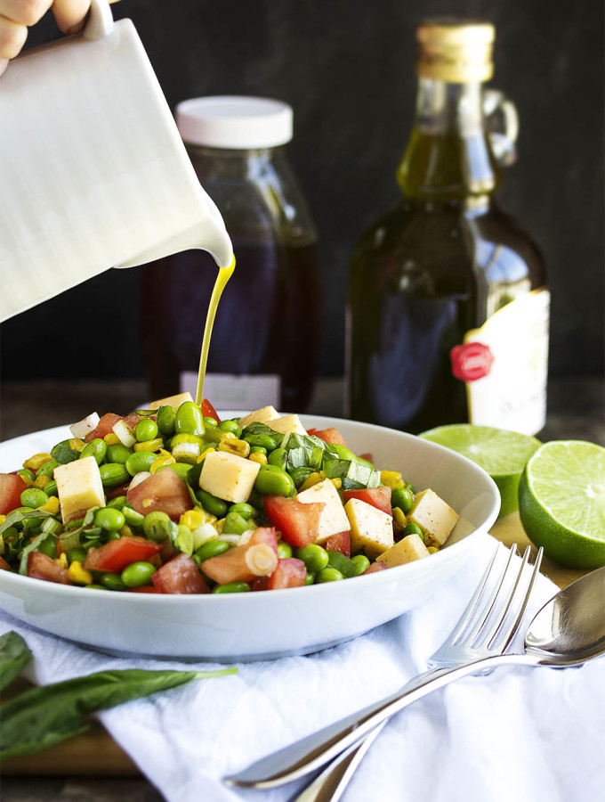 Toasted Corn and Edamame Salad - Quick, healthy and flavorful! Toasted corn, creamy cheese, spicy scallions, and yummy edamame all tossed with a honey lime dressing will have you going back for seconds. Perfect for a summer picnic or cookout. | justalittlebitofbacon.com