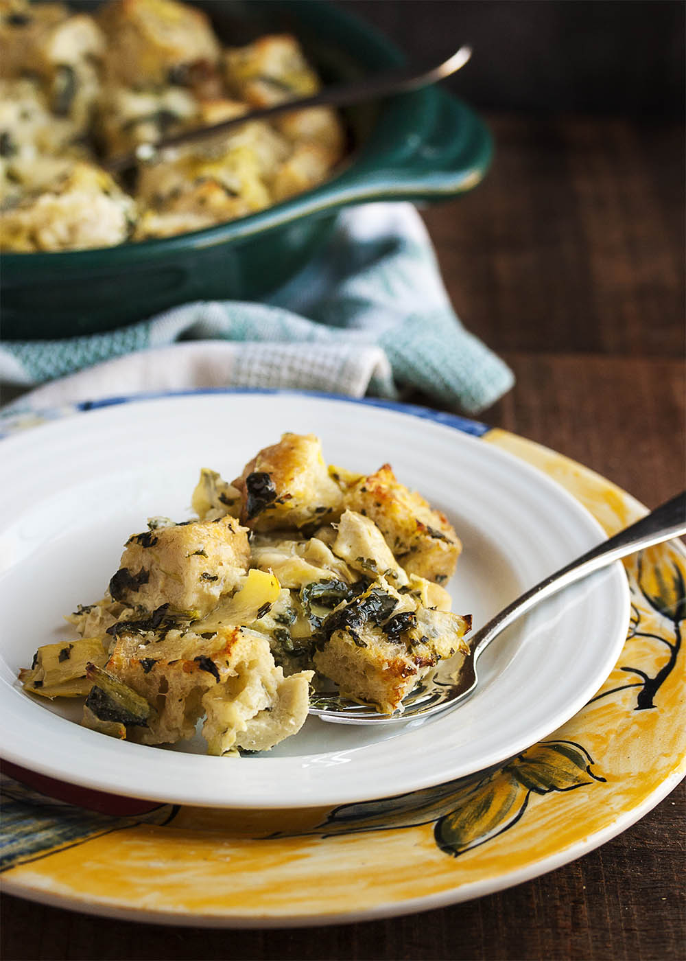 Spinach Artichoke Bread Pudding - This creamy, cheesy bread pudding full of diced artichokes and chopped spinach is the perfect way to use up that stale bread in your cupboard and turn it into a yummy, flavor-packed side dish. | justalittlebitofbacon.com