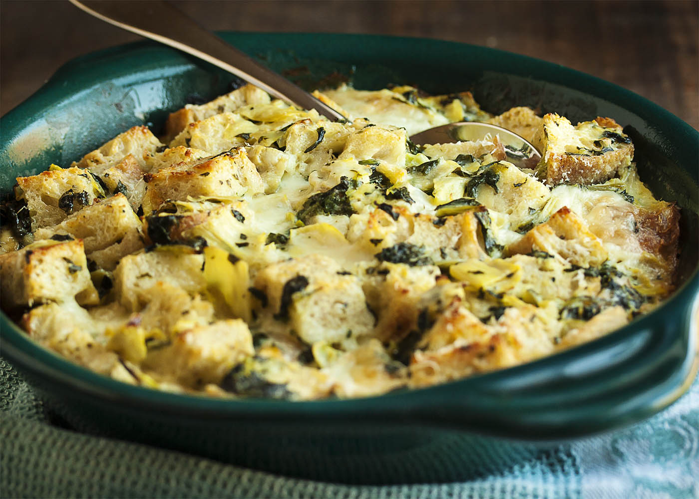 Spinach Artichoke Bread Pudding - This creamy, cheesy bread pudding full of diced artichokes and chopped spinach is the perfect way to use up that stale bread in your cupboard and turn it into a yummy, flavor-packed side dish. | justalittlebitofbacon.com