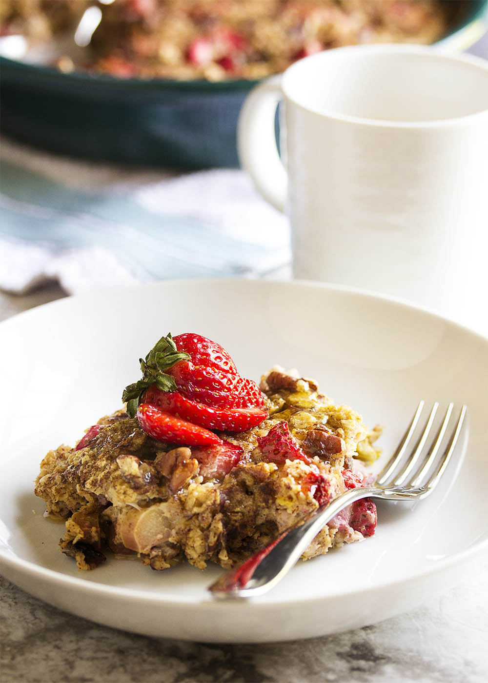 Strawberry Rhubarb Baked Oatmeal - This baked oatmeal smells like a cross between strawberry rhubarb pie and pancakes as it bakes. And it tastes as wonderful as it smells! Pour a little cream over the top, spoon some yogurt next to it, or eat it as is. It's all good. | justalittlebitofbacon.com