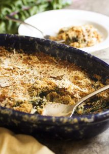 Easy Swiss Chard Gratin - This easy chard gratin is all about the greens as they are cooked in milk and then topped with breadcrumbs and a handful of parmesan. This a great gratin for when you have more greens than you know what to do with - chard, kale, turnip greens, beet greens, spinach. Try a mix of different greens! | justalittlebitofbacon.com