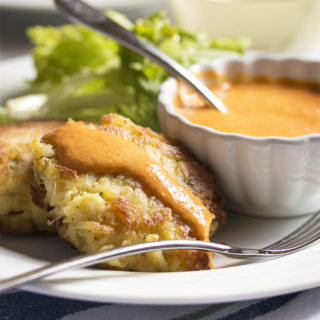 Crab Cakes with Creamy Roasted Red Pepper Sauce - Crab cakes take on Spanish flavors with these paprika spiced cakes which are served alongside a tangy roasted red pepper and cream sauce. | justalittlebitofbacon.com