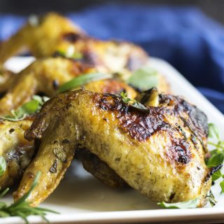 Herb Marinated Grilled Chicken Wings - Grilled chicken wings take on Italian flavors when they are marinated in fresh herbs and lemon and then grilled to crispy perfection. Great for cookouts! | justalittlebitofbacon.com