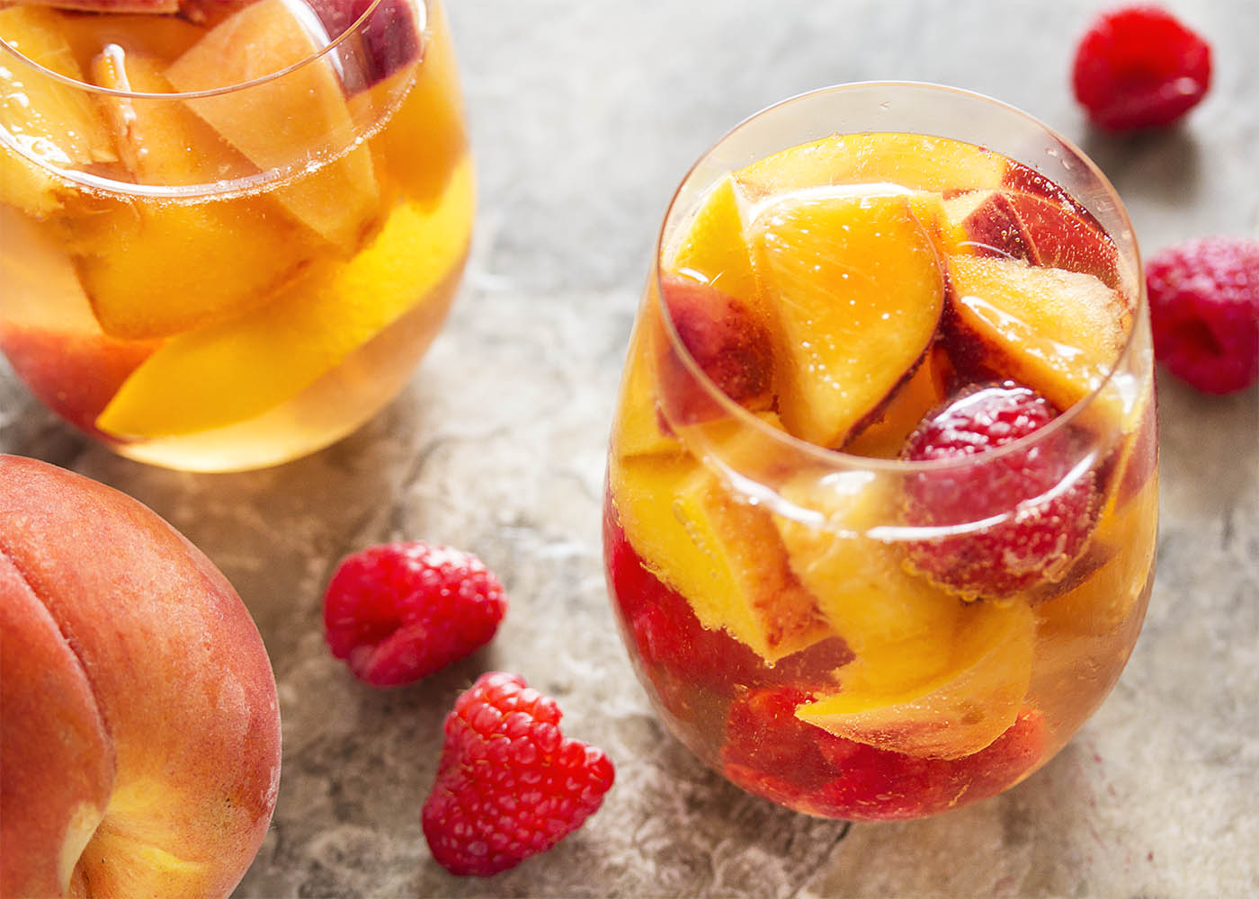 This sparkling white peach sangria is super easy to mix together and just as easy to enjoy on a warm day. Not too sweet and full of fizz from the bubbly, it's the taste of summer in a glass! | justalittlebitofbacon.com