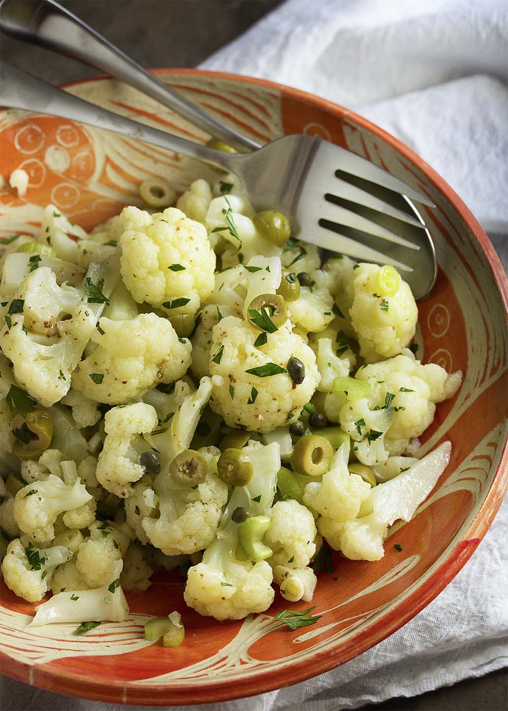 Cold cauliflower salad is a great year-round salad filled with tender cauliflower, briny capers, meaty green olives and plenty of fresh parsley. | justalittlebitofbacon.com