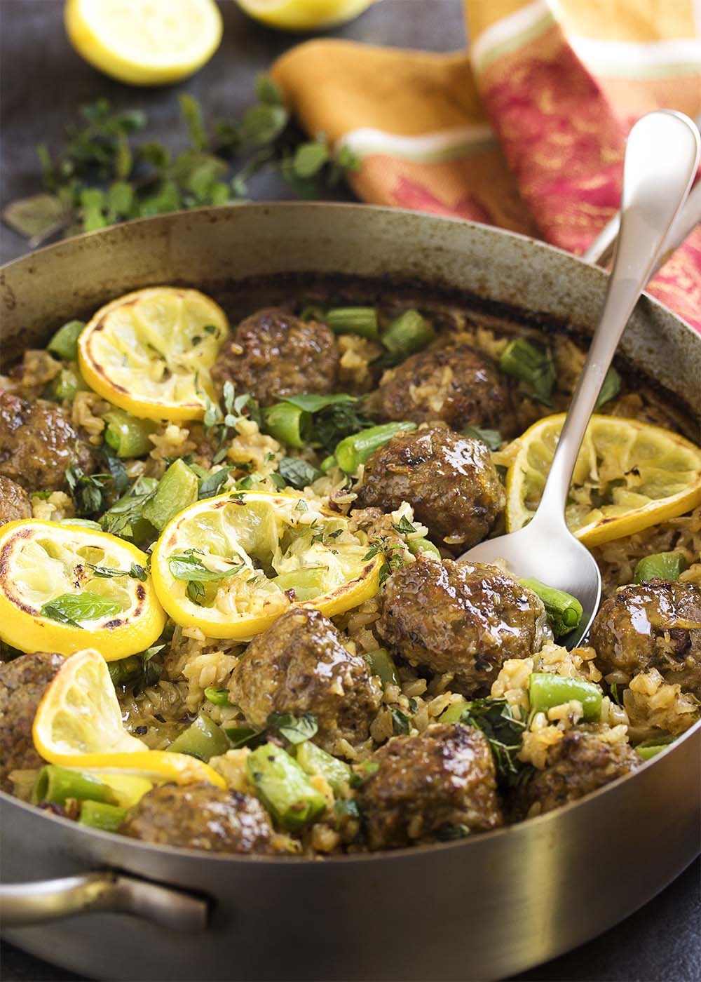 Great and easy one pot meal which starts on the stove and finishes in the oven! Greek lamb meatballs and brown rice is a healthy, complete meal full of the flavors of mint and thyme and finished with a crumble of feta. | justalittlebitofbacon.com