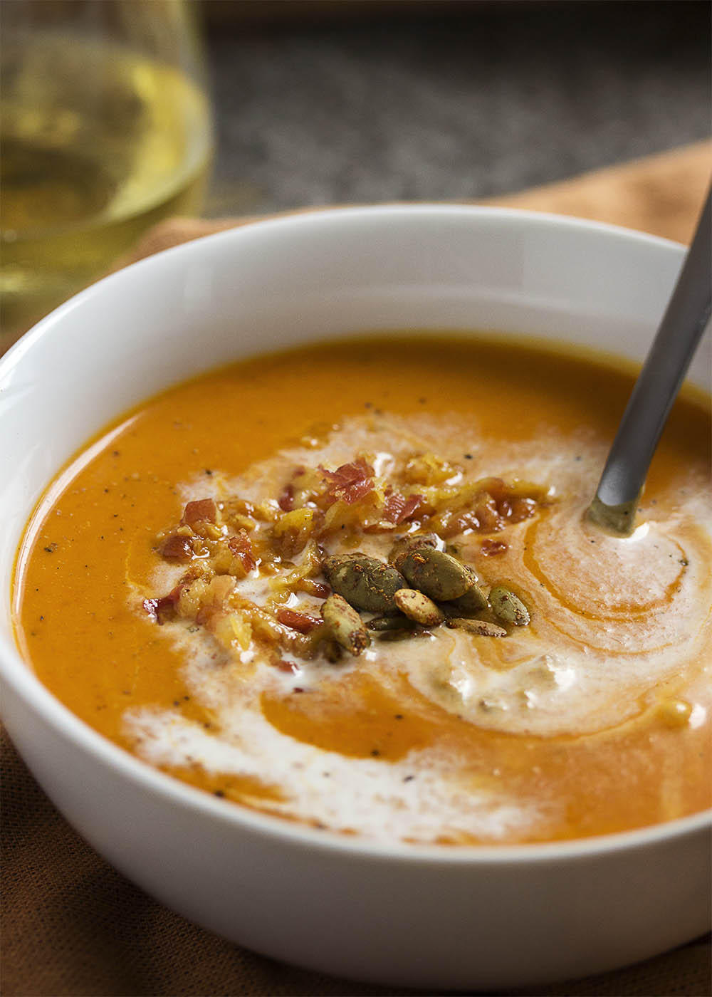 This creamy, spicy roast pumpkin soup is full of Spanish flavors like paprika and roasted red peppers and topped with crispy pancetta. | justalittlebitofbacon.com
