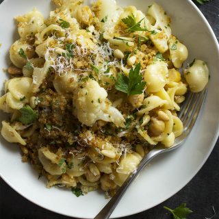Orecchiette is tossed with sauteed cauliflower and toasted pine nuts, then topped with crispy bread crumbs, in this easy Italian vegetarian weeknight pasta dinner. | justalittlebitofbacon.com