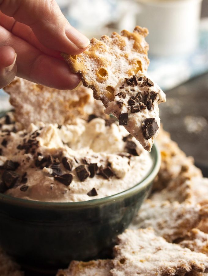 This easy to make ricotta cannoli dip is full of cinnamon and fresh ricotta and topped with chopped chocolate. Perfect for a party! All the yumminess of cannolis without the fuss and bother of making and filling cannoli shells. | justalittlebitofbacon.com