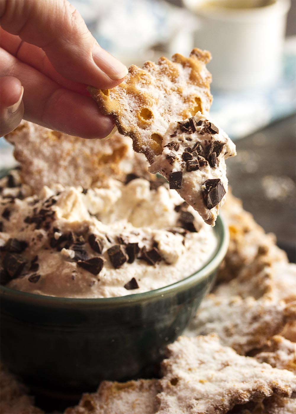 This easy to make ricotta cannoli dip is full of cinnamon and fresh ricotta and topped with chopped chocolate. Perfect for a party! All the yumminess of cannolis without the fuss and bother of making and filling cannoli shells. | justalittlebitofbacon.com