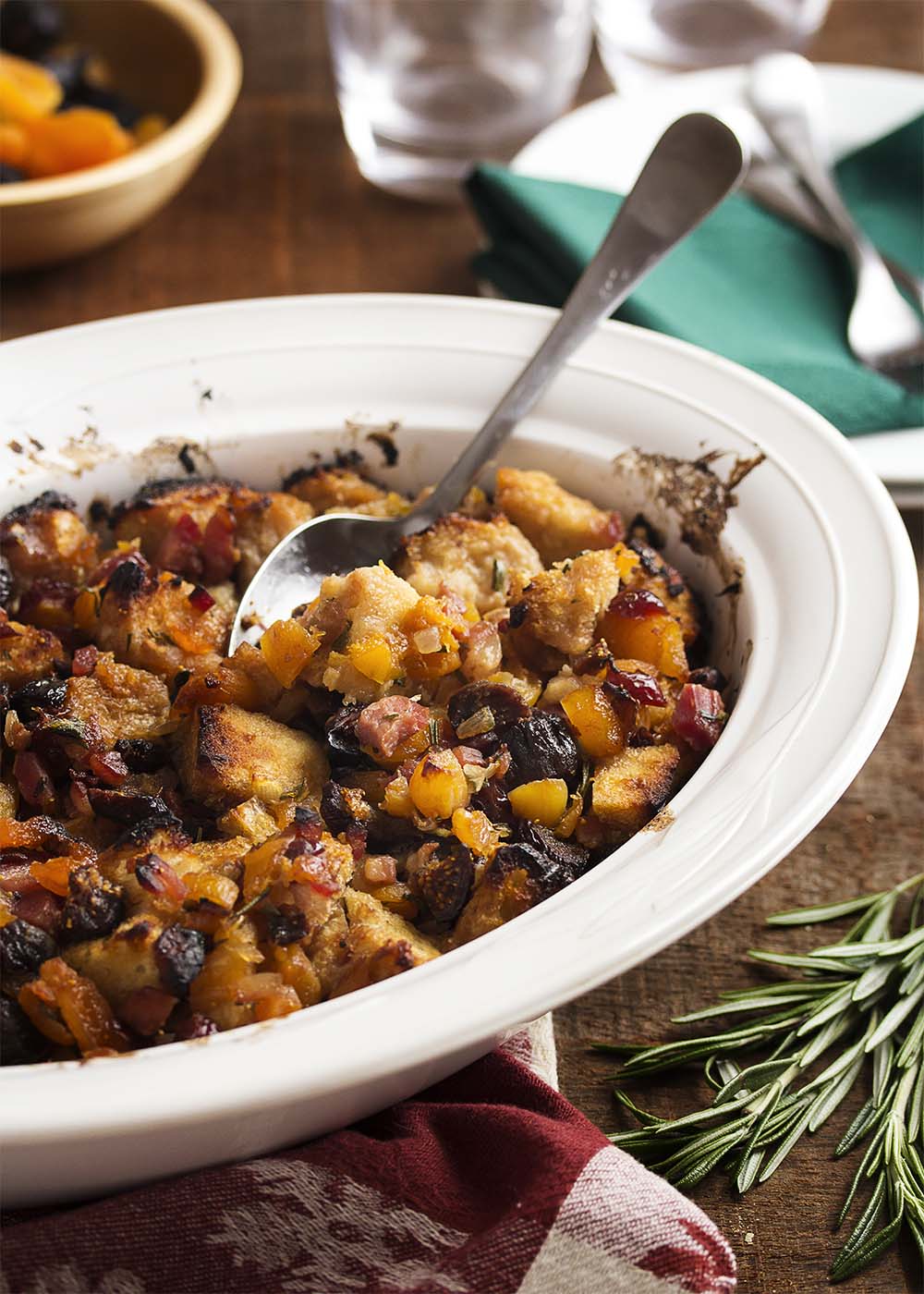 This stuffing is full of apricots, figs, and cranberries all tossed with sourdough bread cubes and flavored with pancetta and rosemary. A great accompaniment to roast pork! | justalittlebitofbacon.com
