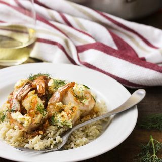 Juicy, plump shrimp are flambeed in brandy then topped with feta before being broiled over a bed of tomatoes in this classic Greek dish! | justalittlebitofbacon.com