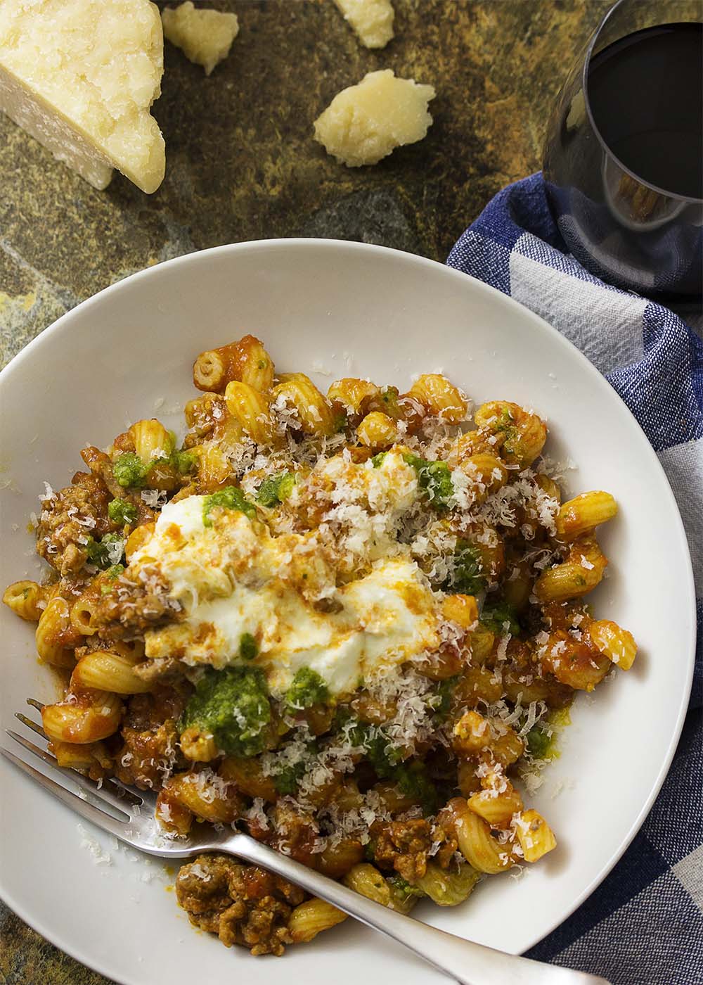 Dinner comes together in a flash with this recipe for kid-pleasing, one-pot ground beef pasta skillet topped with pesto and ricotta. | justalittlebitofbacon.com