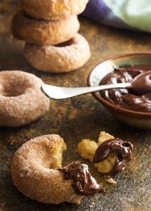 Churros just got a little bit healthier! No deep frying needed. Baked churro donuts are make in a donut pan and rolled in cinnamon sugar. This means you can totally justify the spicy chocolate sauce to dip them in. | justalittlebitofbacon.com