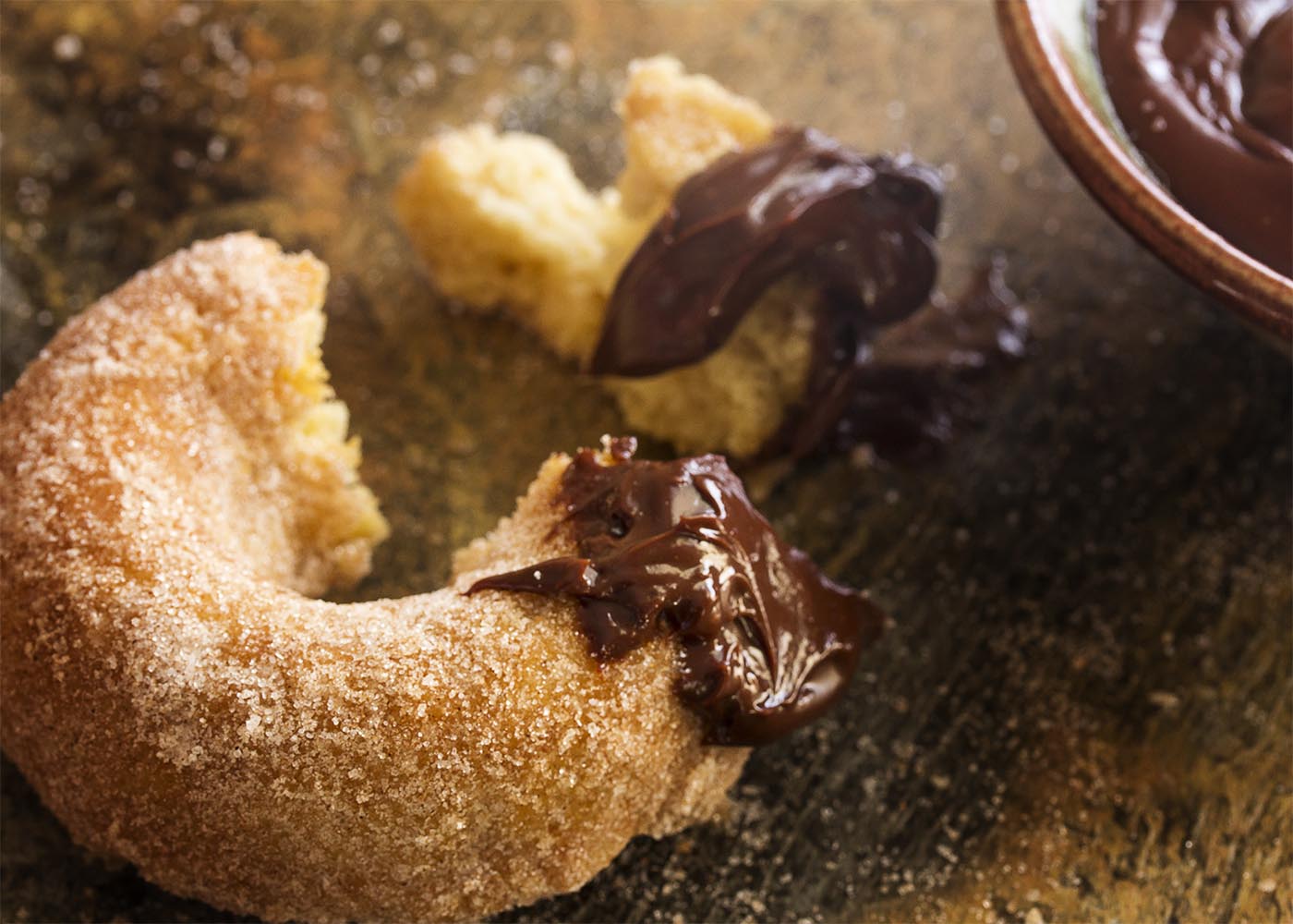 Churros just got a little bit healthier! No deep frying needed. Baked churro donuts are make in a donut pan and rolled in cinnamon sugar. This means you can totally justify the spicy chocolate sauce to dip them in. | justalittlebitofbacon.com