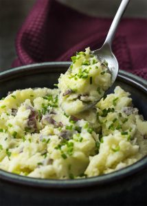 This recipe for creamy buttermilk garlic mashed potatoes topped with chives is super easy comfort food great for holidays or any day. | justalittlebitofbacon.com