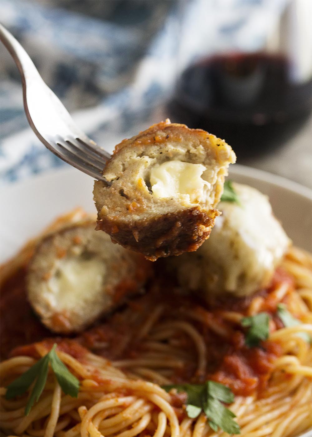 Crispy, mozzarella stuffed and juicy! These chicken parmesan meatballs are full of gooey mozzarella and rolled in breadcrumbs to make a crispy crust. Serve with marinara sauce and pasta. | justalittlebitofbacon.com