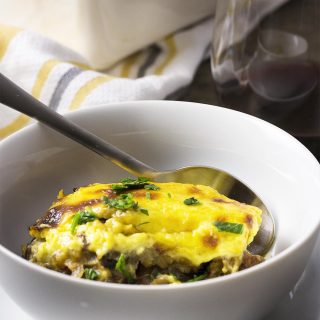 Greek comfort food at its best! Layers of eggplant and lamb are covered with creamy bechamel sauce and then baked until bubbly and golden in this leftover lamb moussaka. | justalittlebitofbacon.com