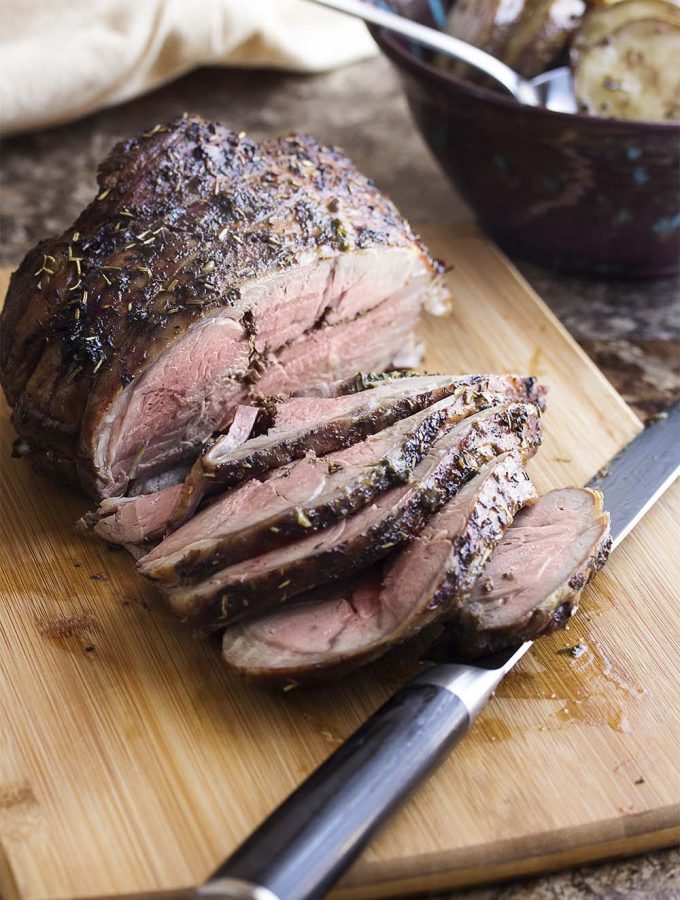 Keep the oven temperature low for a low-stress slow roasted Greek lamb leg which is tender and juicy and pink all the way through! Add some potatoes to the pan for a great, Greek-style meal. | justalittlebitofbacon.com