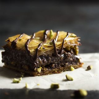 This chocolate baklava is packed full of pistachios and bittersweet chocolate, then drizzled with a honey syrup to make wonderfully rich Greek dessert! | justalittlebitofbacon.com