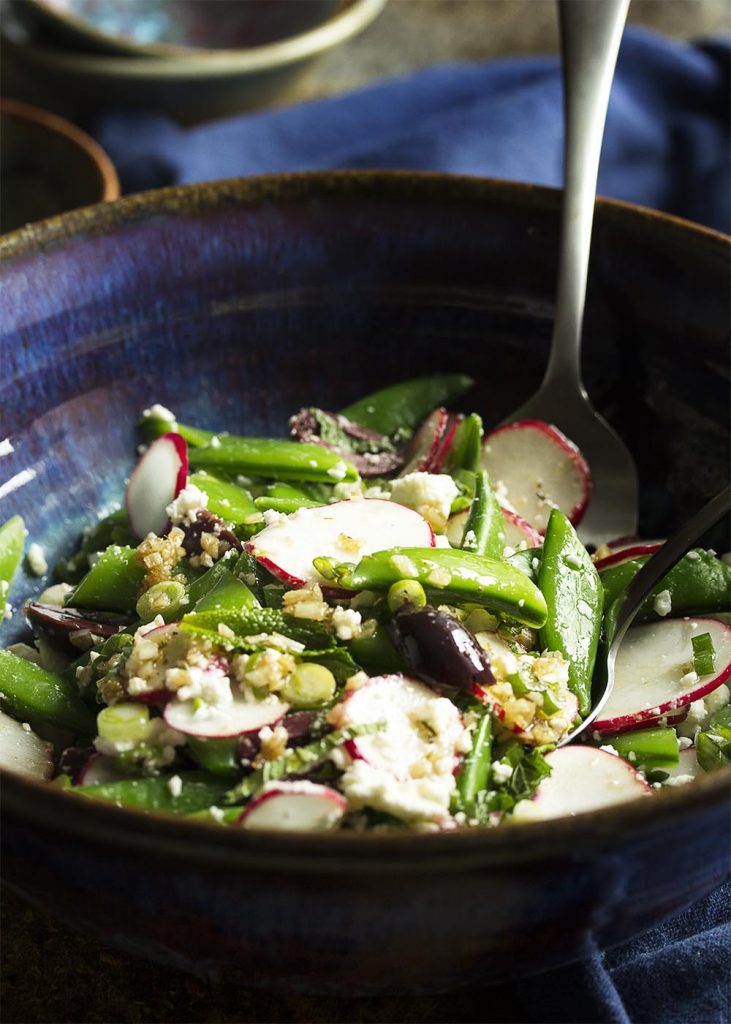 Celebrate spring with sweet snap peas and spicy radishes all tossed with feta, kalamata olives, and scallions in this Greek snap pea salad. | justalittlebitofbacon.com