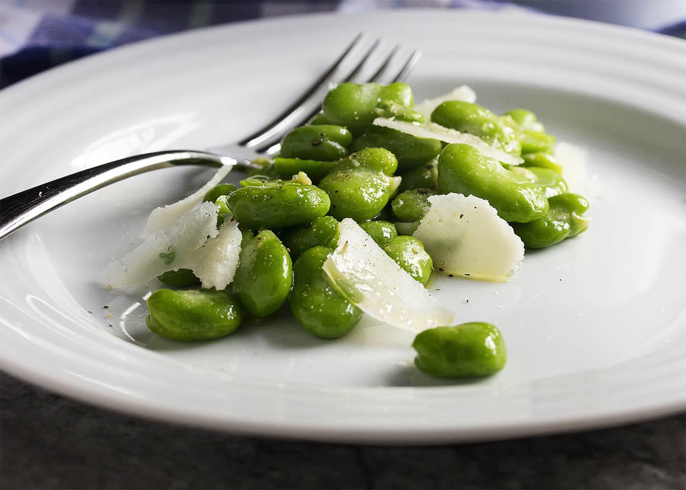 One great way to enjoy fava beans is in this healthy spring inspired fresh fava bean and parmesan salad, which is tossed lightly with a little olive oil and sprinkled with salt and pepper. Simple, but oh so good! | justalittlebitofbacon.com