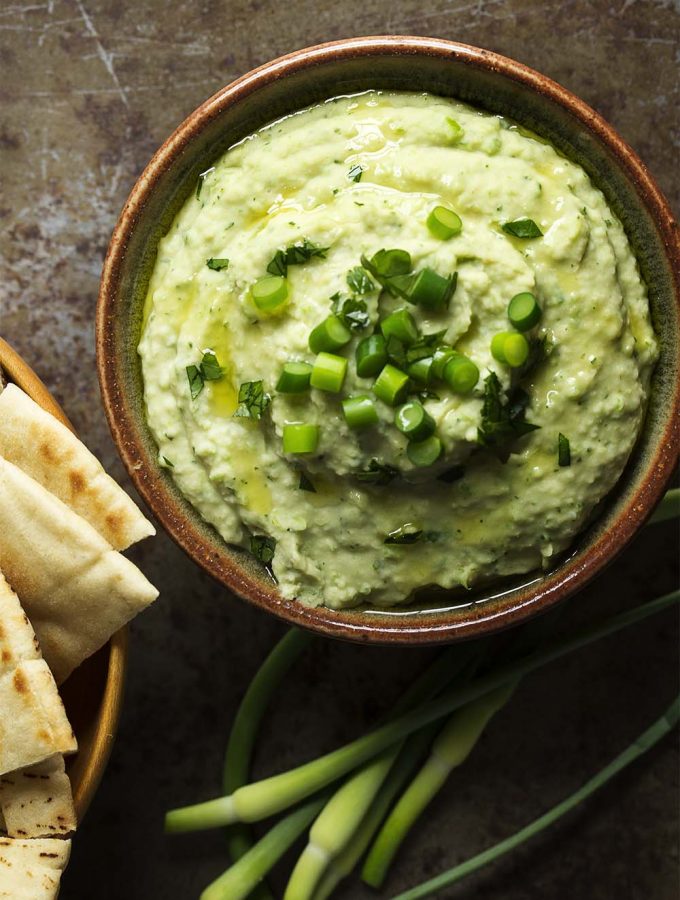 Wondering what to do with garlic scapes? Puree them into a quick and creamy, garlicky bean and garlic scape dip! Great as a healthy snack or for a party! | justalittlebitofbacon.com