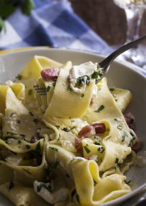 Creamy burrata is tossed with crispy pancetta, chopped herbs, and fresh pappardelle noodles in this quick recipe for pancetta pasta. | justalittlebitofbacon.com