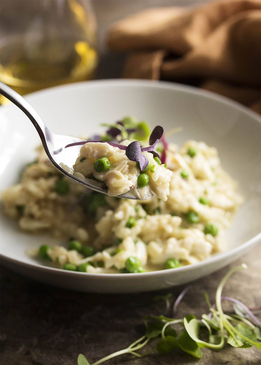 Creamy crab risotto makes a great one-pot meal! Sweet crab meat is mixed with mascarpone and baby peas in this quick dinner. Great for a weeknight or for date night. | justalittlebitofbacon.com