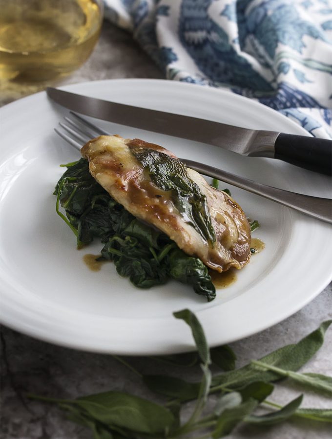 This pork saltimbocca will jump in your mouth! Pork tenderloin topped with prosciutto, fontina, and sage makes a tender and quick cooking meal. Finish off the recipe with a white wine pan sauce and serve with sauteed spinach. | justalittlebitofbacon.com