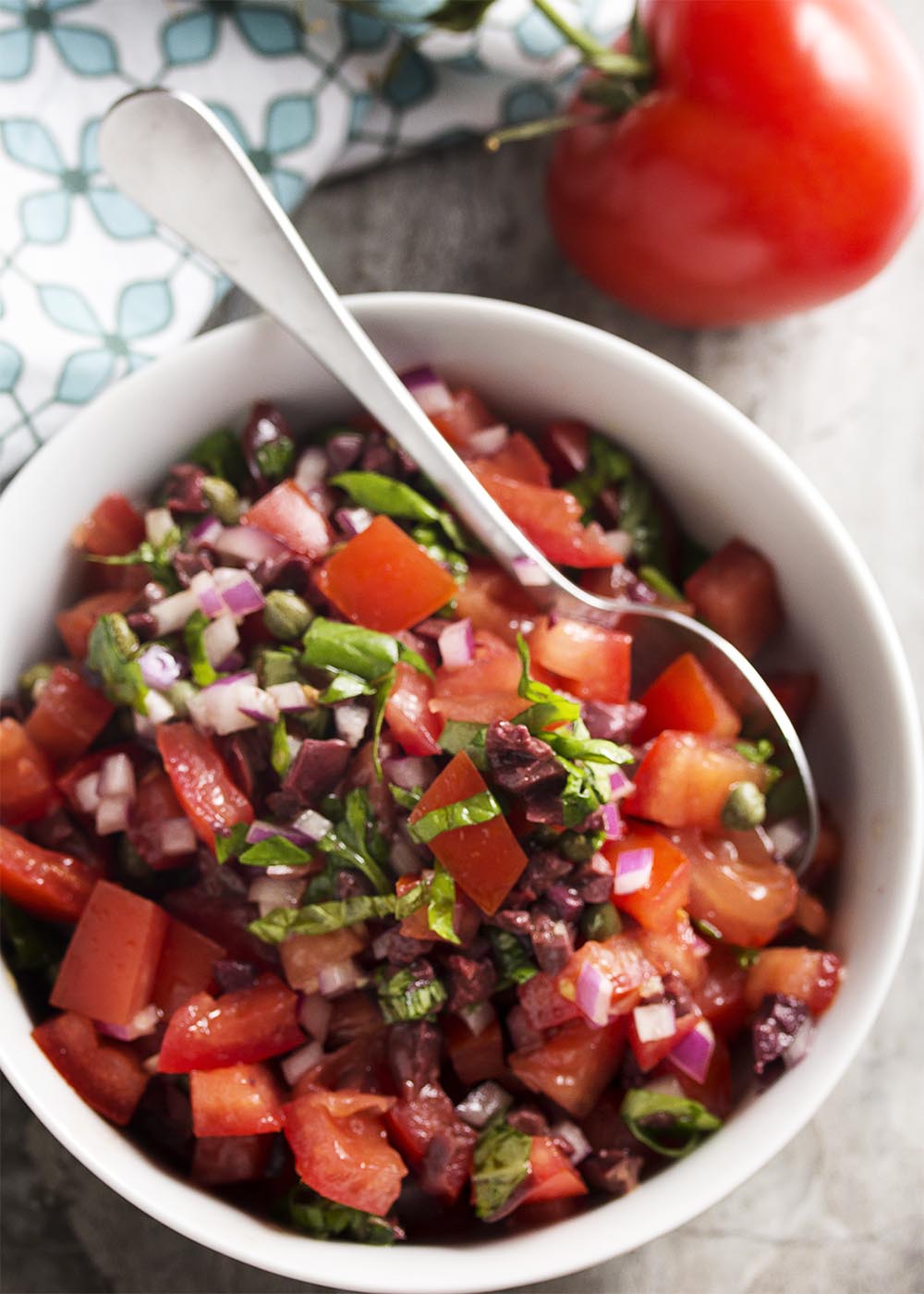 This Italian salsa is full of Italian flavors like fresh tomatoes, capers, black olives, and basil! It's great on grilled meats, bruschetta, or as a dip with chips. | justalittlebitofbacon.com