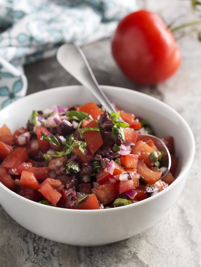 This Italian salsa is full of Italian flavors like fresh tomatoes, capers, black olives, and basil! It's great on grilled meats, bruschetta, or as a dip with chips. | justalittlebitofbacon.com