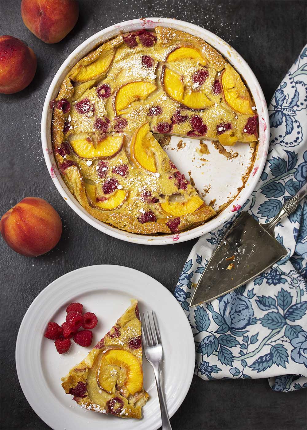 Tender custard filled with fresh fruit! This French recipe for raspberry peach clafoutis makes a great change from pancakes for breakfast and is impressive enough for dessert. | justalittlebitofbacon.com
