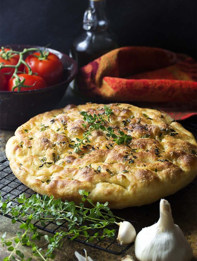 My no-knead focaccia bread with garlic and thyme is made right in a cast iron skillet, giving it a soft and chewy interior and crispy edges. Easy! Great for dinner or for paninis! | justalittlebitofbacon.com