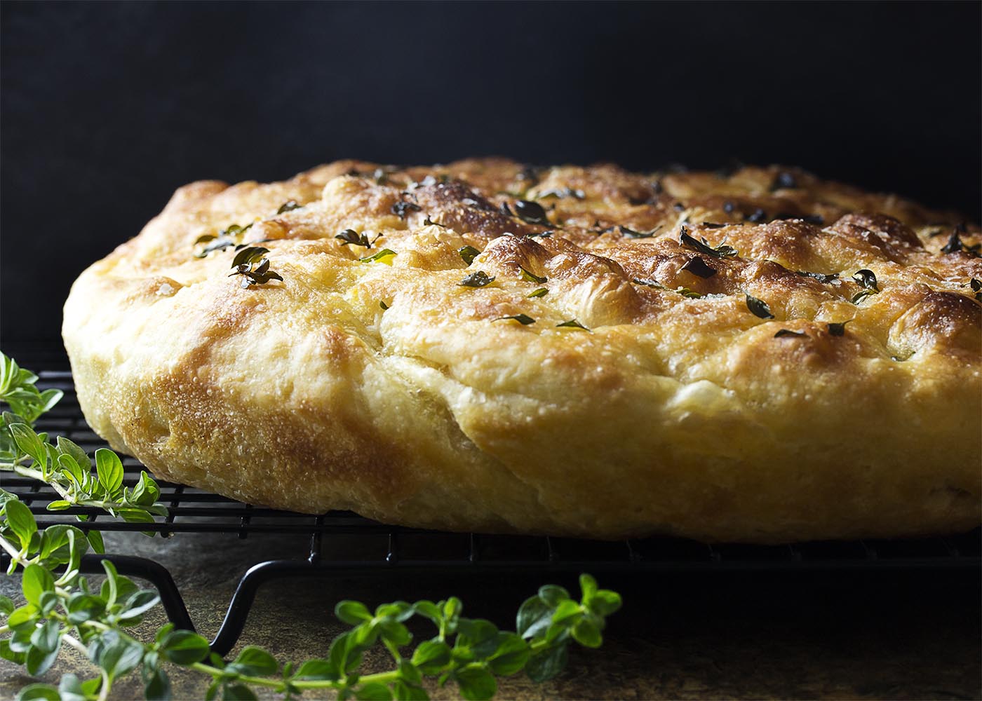 My no-knead focaccia bread with garlic and thyme is made right in a cast iron skillet, giving it a soft and chewy interior and crispy edges. Easy! Great for dinner or for paninis! | justalittlebitofbacon.com