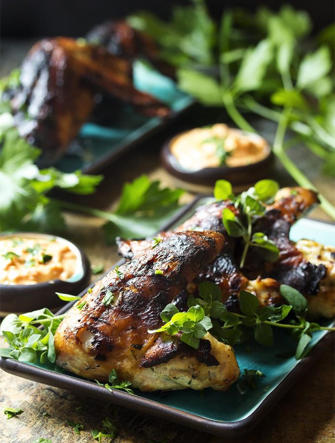 Yogurt marinated chicken wings are so flavorful, tender and juicy which makes these grilled Greek wings a fun and easy party food! Great by themselves or with a dipping sauce, like roasted pepper feta dip or tzatziki sauce. | justalittlebitofbacon.com