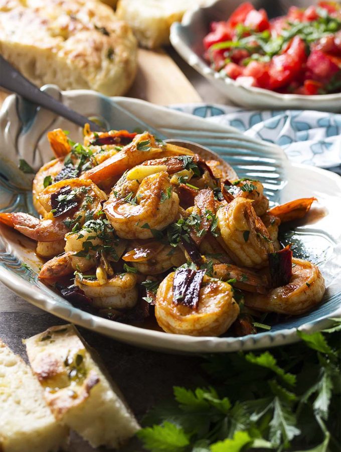 Plump and juicy shrimp, soft sliced garlic, and sweet and smoky paprika combine in this classic tapas recipe for Spanish garlic shrimp. Quick and easy! Make sure you have plenty of bread to soak up the flavorful olive oil! | justalittlebitofbacon.com