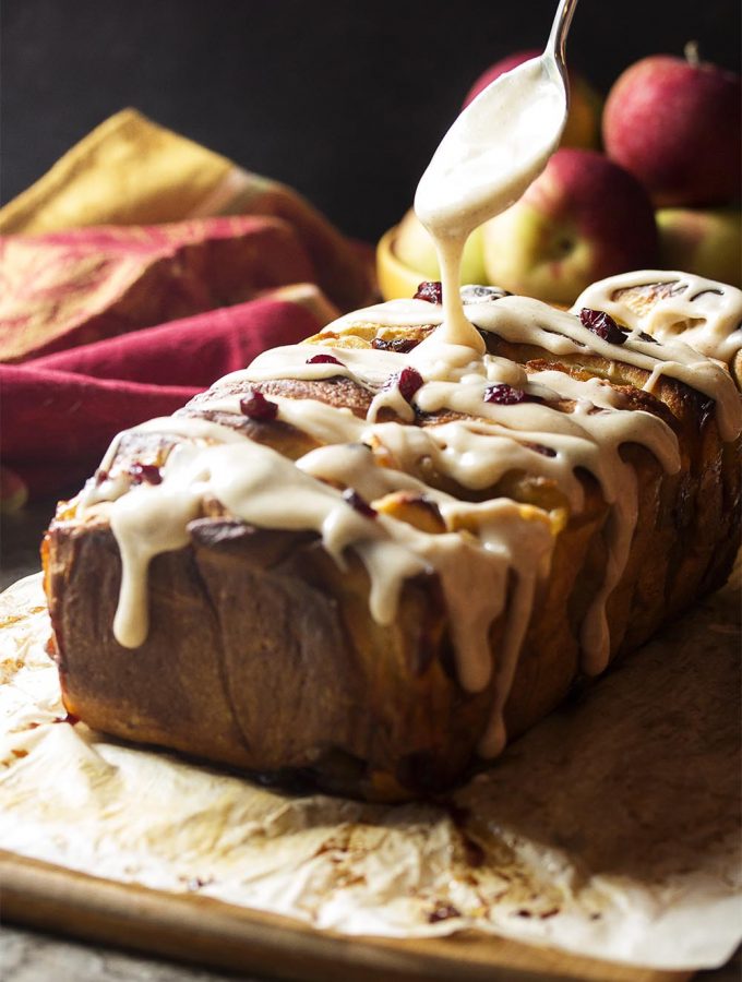 Apple pie filling and bourbon soaked cranberries are sandwiched in between layers of rich bread dough in this apple pull apart bread. | justalittlebitofbacon.com