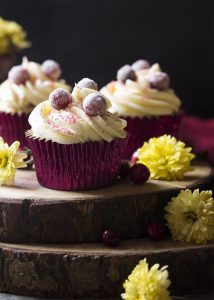 Tender vanilla cake is filled with fresh cranberries and orange zest, then topped with cream cheese frosting in these cranberry orange cupcakes. Great for Thanksgiving or Christmass dessert! | justalittlebitofbacon.com