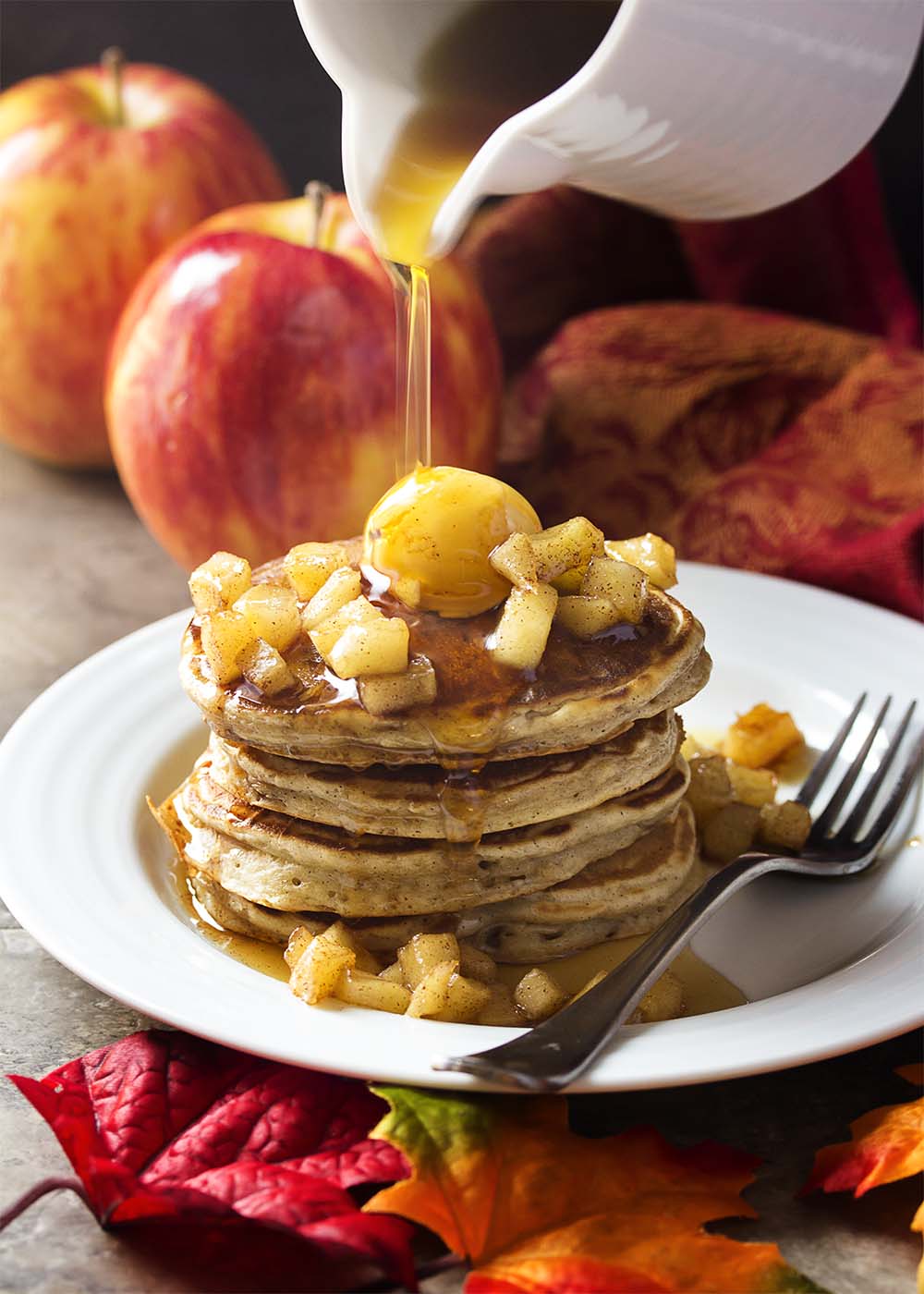 My favorite sour cream pancake batter is mixed with sauteed spiced apples in these apple cinnamon pancakes for the perfect fall and winter breakfast. | justalittlebitofbacon.com