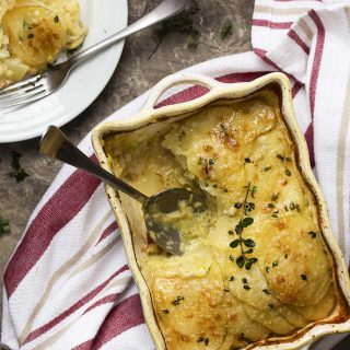 Creamy, buttery yellow potatoes and mild leeks combine with sharp cheddar and pancetta in this rich and cheesy potato leek gratin. | justalittlebitofbacon.com