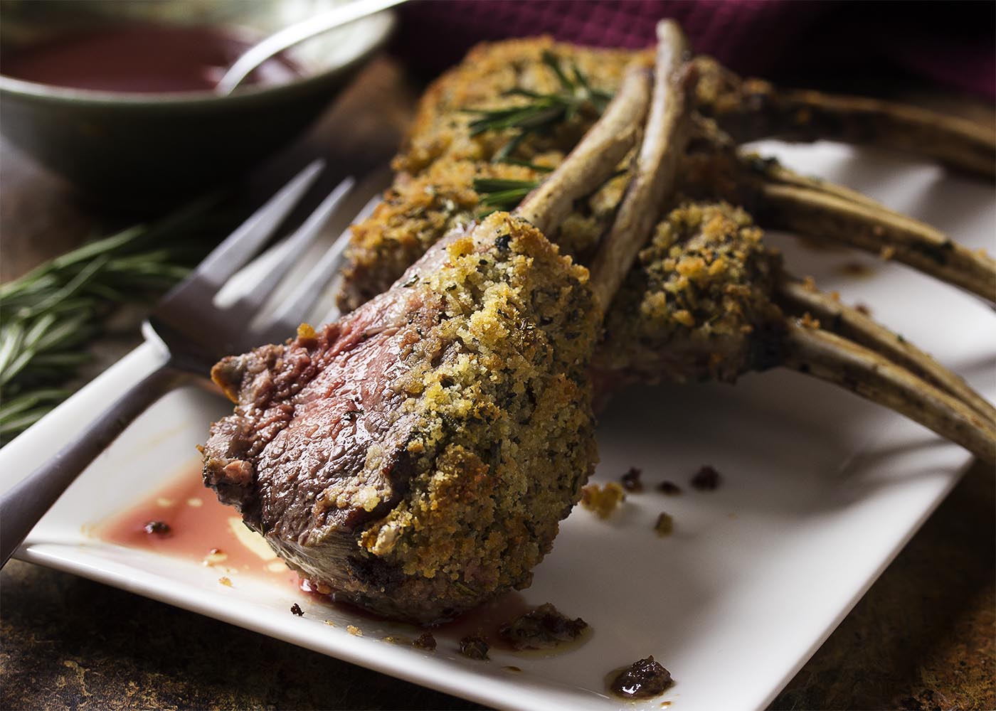 For the best herb crusted rack of lamb, marinate it overnight, cover in breadcrumbs, oven roast, and pair it with with a silky red wine sauce. This elegant recipe is perfect for the holidays or for a dinner party any time of the year. | justalittlebitofbacon.com