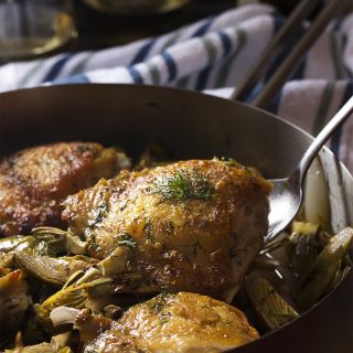 Looking for a new chicken recipe? Love artichokes? My pan roasted chicken and artichokes with a white wine lemon pan sauce is a great skillet dinner full of Mediterranean flavors and a great way to use fresh, baby artichokes. | justalittlebitofbacon.com