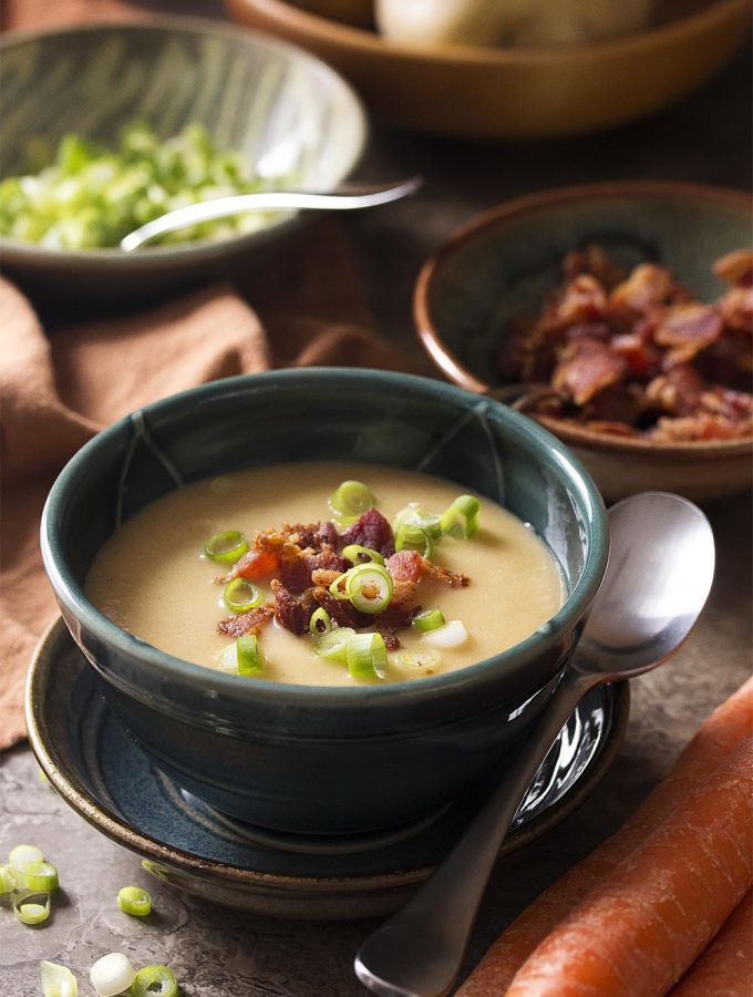 My creamless creamy potato carrot soup is full of flavor from buttery yellow potatoes, sweet carrots, bacon fat, and sharp cheddar cheese. Pureed until smooth and topped with crispy bacon and scallions, this soup is great comfort food for dinner on chilly nights.
