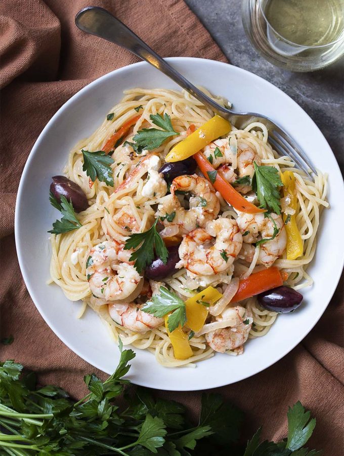 Greek pasta with shrimp, feta, olives is a great and easy skillet dinner full of tender shrimp, salty feta and olives, a good glug of olive oil, and plenty of garlic. And you get to flambe! What could be better?